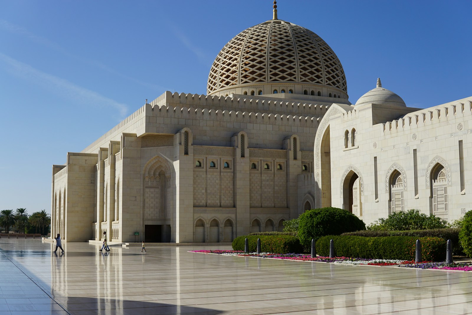The latticed dome and white stone facade of the Sultan Qaboos Grand Mosque in Muscat